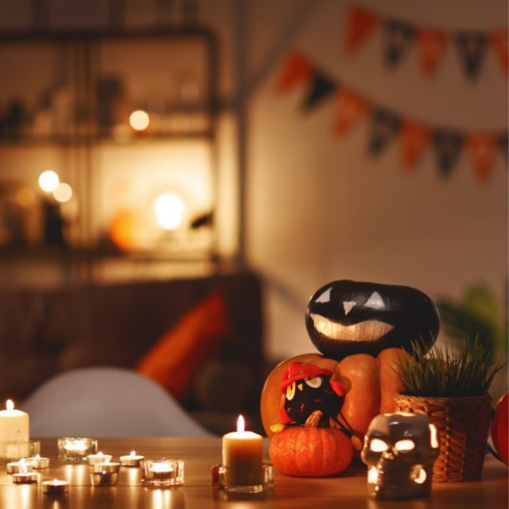 Calabazas de Halloween con velas decorando una mesa.