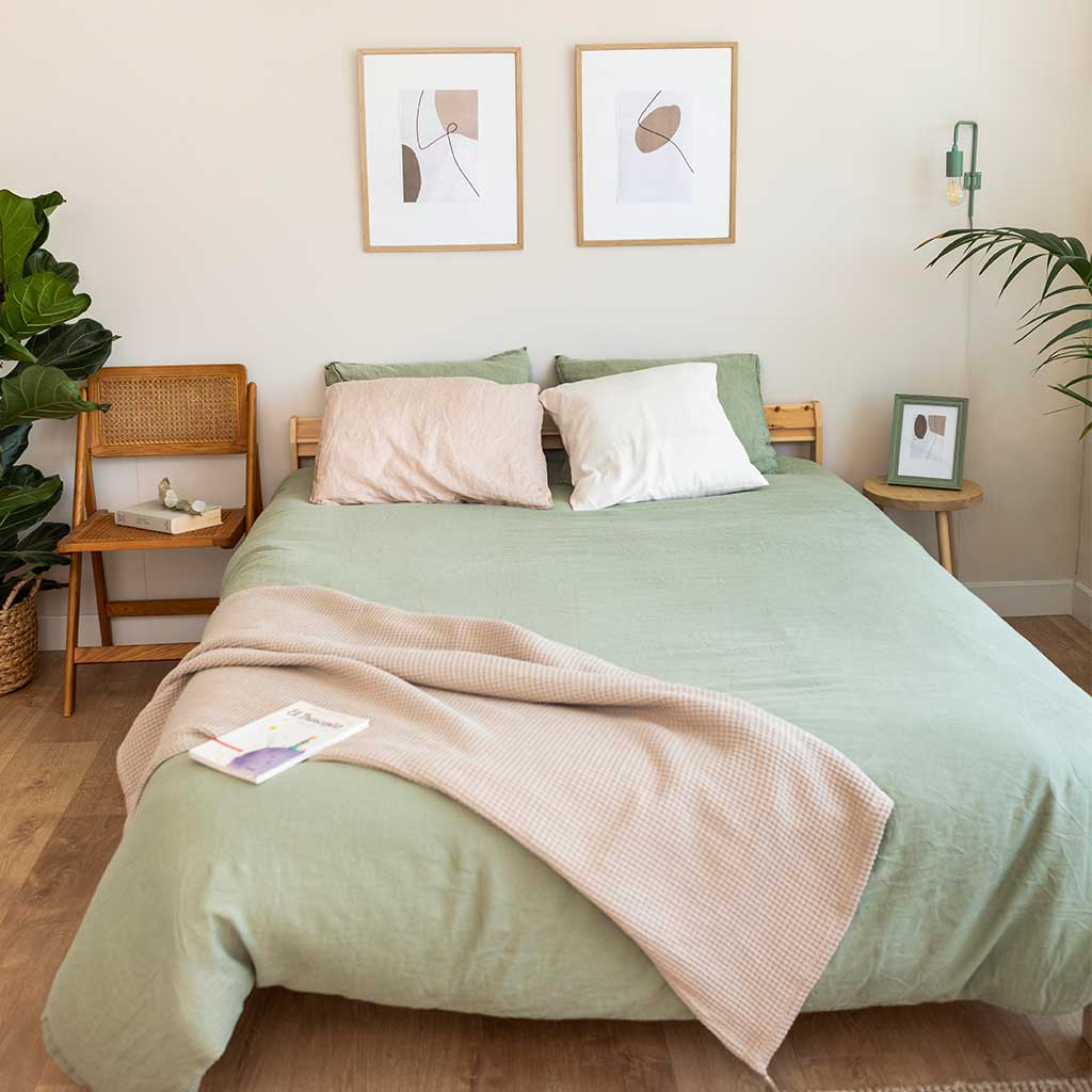 Habitación pequeña con ropa de cama sencilla en colores pastel.